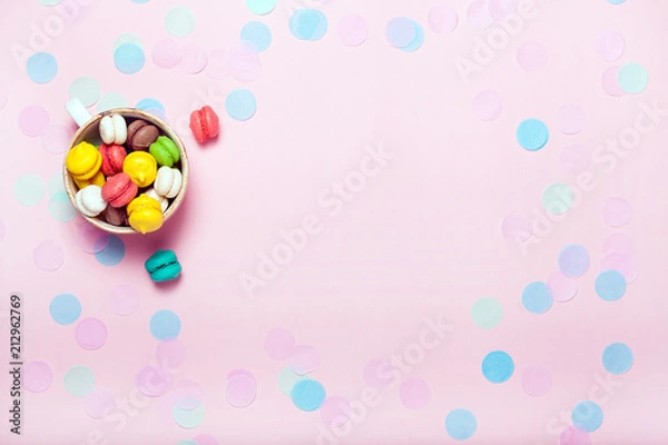 Fototapeta Cup full of macarons on pink background.