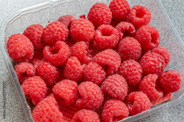 Obraz Friche reife geerntete Himbeeren in einer durchsichtigen Plastikschale aus dem Supermarkt