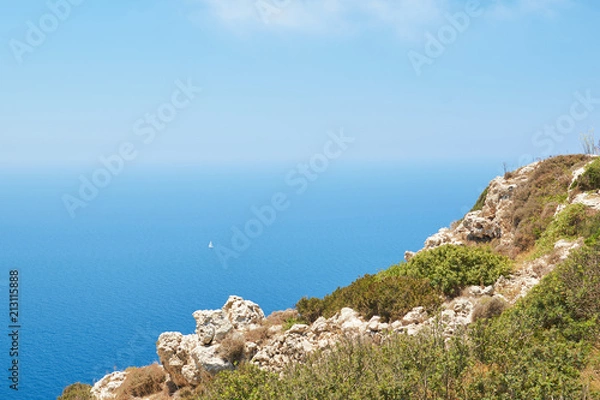 Fototapeta Lonely boat in the sea near Dingli cliffs. Malta