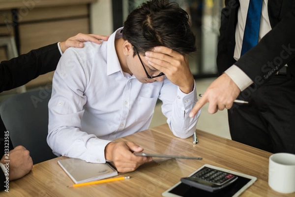 Fototapeta businessman shouted to the employee and point his finger to report, he is very angry for Reported sales decrease. employee is stressed and put hands on his head.