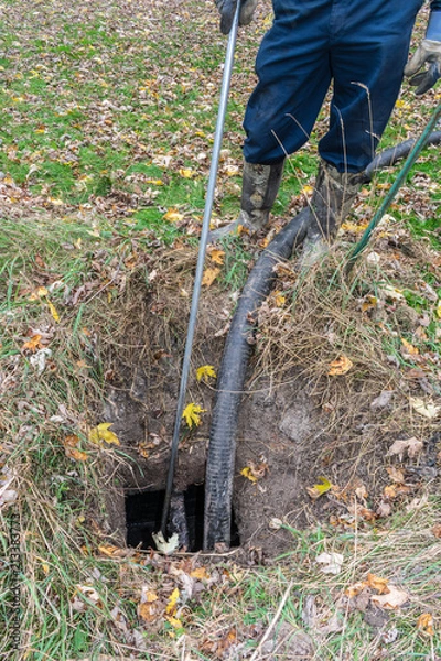 Obraz Worker pumping out a home septic tank