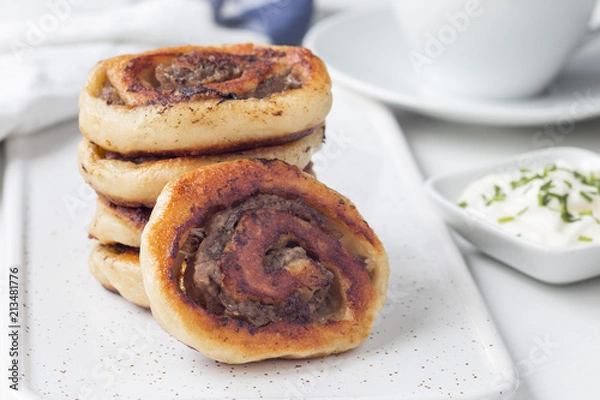 Fototapeta Fried savoury cottage cheese pies with minced meat on a white board, served with yogurt, horizontal