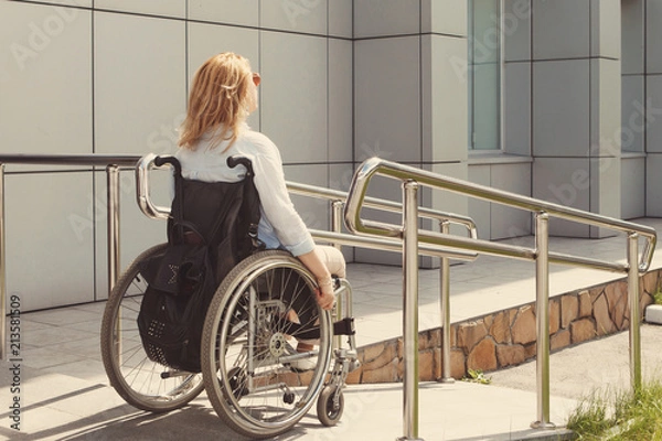 Fototapeta Woman in a wheelchair using a ramp