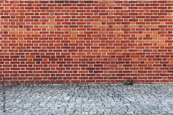 Obraz Retro red brick wall and cobblestone pavement.