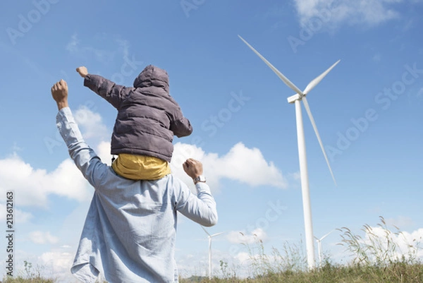 Obraz happy father and son playing at the Wind turbines generating electricity. Having quality family time together.