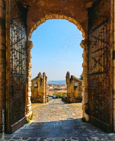 Fototapeta wooden open gate with view over city in medieval castle on the hill in little town Melfi, Basilicata Italy                     