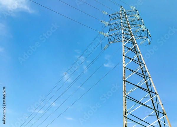 Fototapeta High voltage tower with blue sky in background.