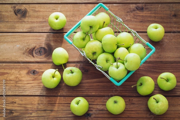 Obraz apples in a shopping basket on a wooden table