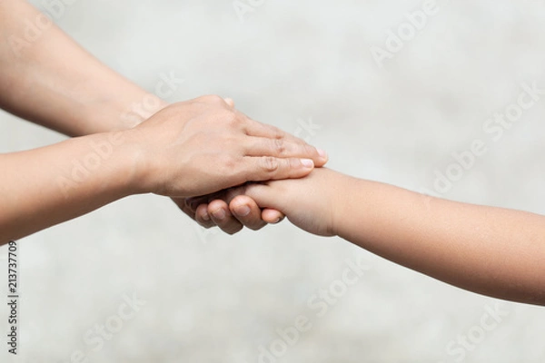 Fototapeta hand of parent and child on the background blurred nature.Mother holding hands baby