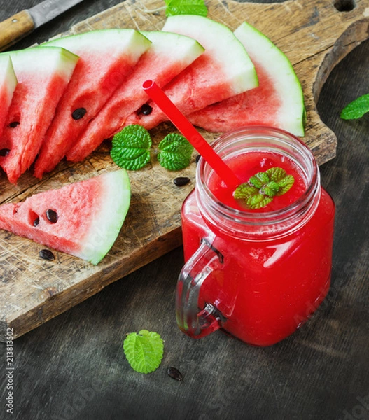 Obraz Watermelon juice and pieces of watermelon on a dark wooden background, rustic style