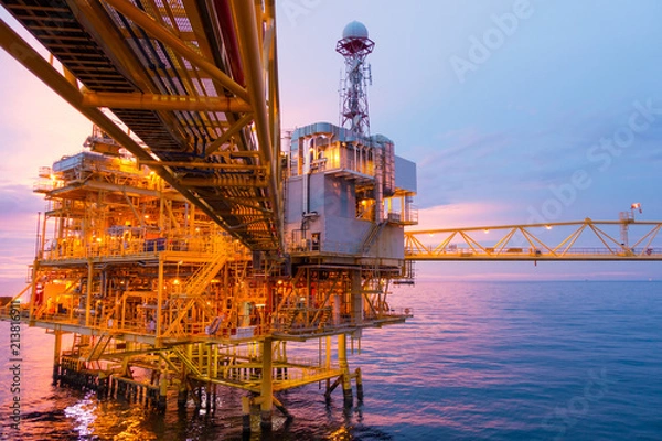 Fototapeta Offshore construction platform for exoloration and production oil and gas with bridge in evening time for power energy of the world concept