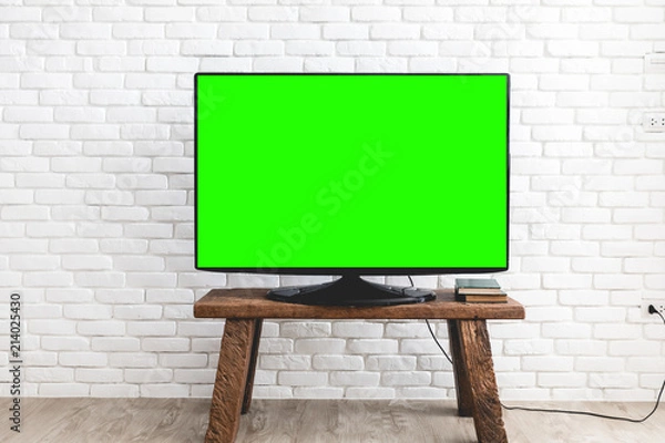 Obraz Empty green flat TV screen on wood stand.