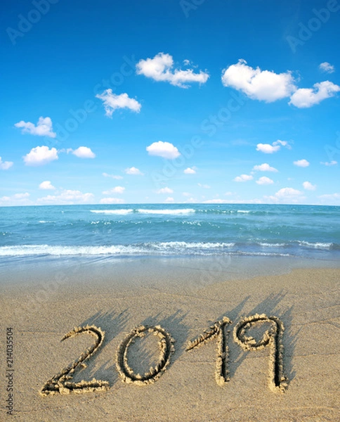 Fototapeta 2019 written on the sand of a beach. Travel and New Year concept.