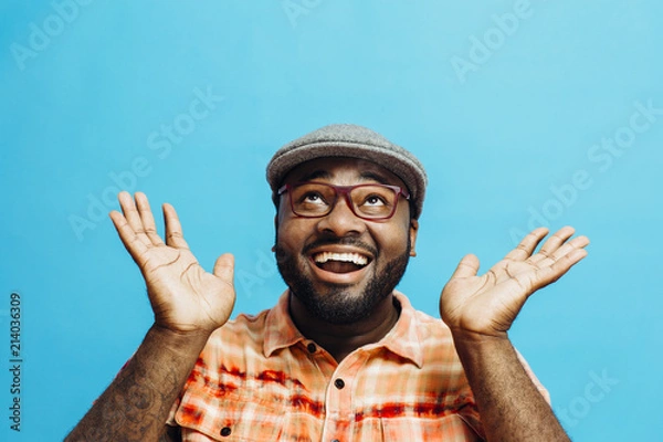 Obraz It's incredible! Portrait of a happy and excited man looking up with mouth open and both arms up