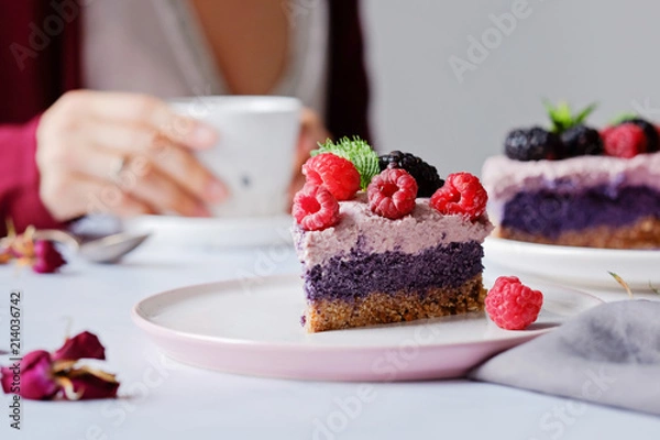 Fototapeta Raw vegan cake with raspberries and bluberries on white table