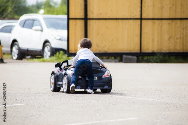 Obraz child pushes the car
