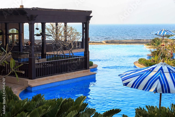 Obraz View of terrace lounge bar, restaurant, swimming pool, beach and ocean.