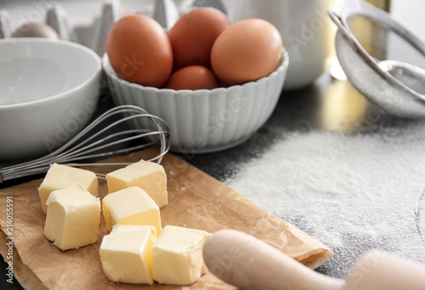 Fototapeta Cut butter, whisk and eggs on kitchen table. Bakery workshop