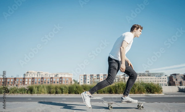 Obraz Young attractive man riding longboard in the park.