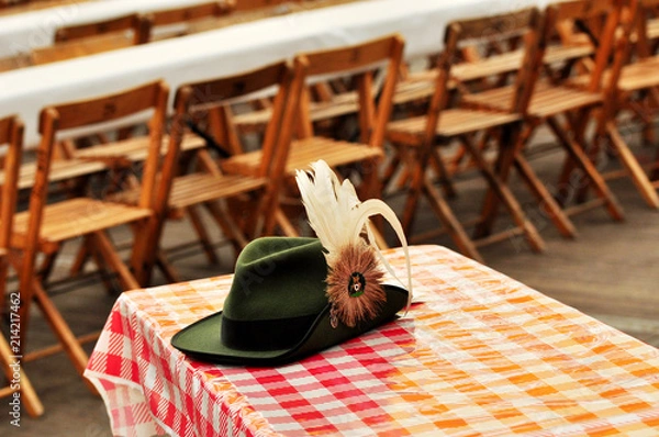 Obraz Schützenfest, zielona czapka karabinowa z wiecznym piórem na stole w namiocie