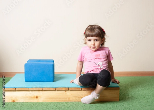 Obraz little girl, 3 years old. doing yoga with cubes