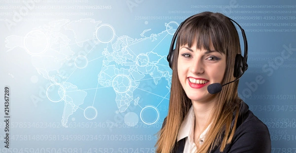 Fototapeta Young female telemarketer with blue background and world map and numbers behind her