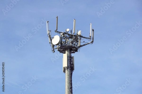 Fototapeta Antenna tower of telecommunication and signal repeater of mobile communication with blue sky, over building