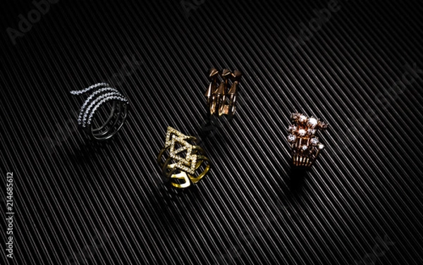 Obraz Golden, silver and bronze rings collection on black textured paper