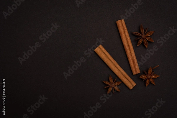 Obraz cinnamon sticks and cardamom on a black background top view with copy space for text