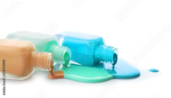 Fototapeta Open bottles of nail polishes on white background