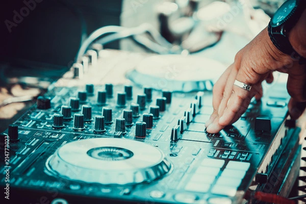 Fototapeta DJ plays and mix music on digital midi mixer controller