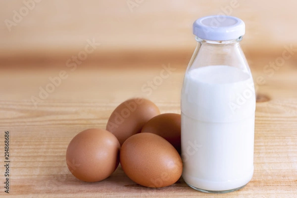 Obraz Prepare breakfast with eggs and milk on a wooden table.