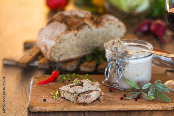 Obraz Rustic pâté\pate made from pork liver in a glass jar and a slice of homemade rustic french bread with garlic.