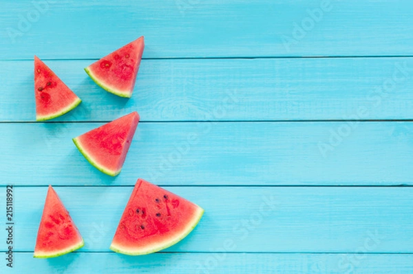Fototapeta Top view of watermelon slices on a turquoise wooden background