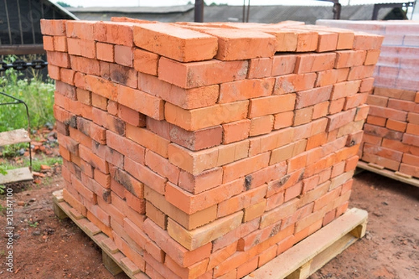 Obraz The bricks are stacked on wooden pallets and prepared for sale. Clay brick is an ecological building material.