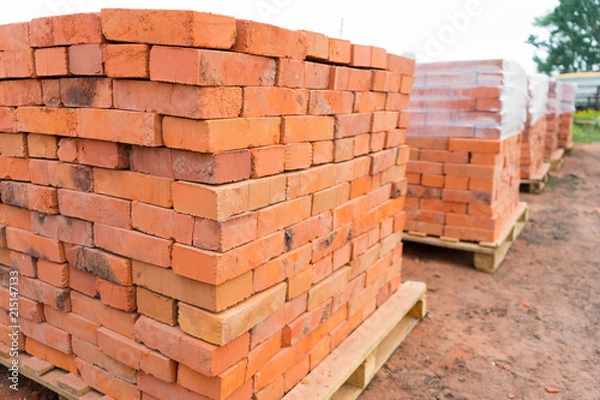 Obraz Cegły układane są na drewnianych paletach i przygotowywane do sprzedaży. Cegła ceramiczna to ekologiczny materiał budowlany.