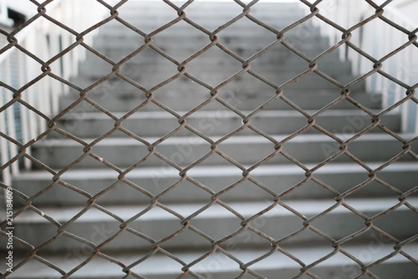Fototapeta Chain link fence in front of stairway
