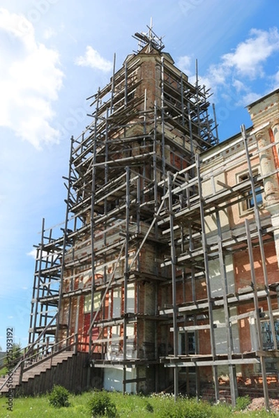 Fototapeta ancient stone Church in the scaffolding for restoration