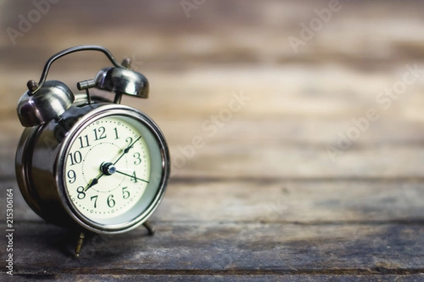 Fototapeta Retro alarm clock on a wooden table.
