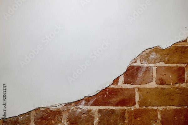 Fototapeta Part of the red brick wall of an old house with a figured pattern of white putty. Background, contrasting texture.
