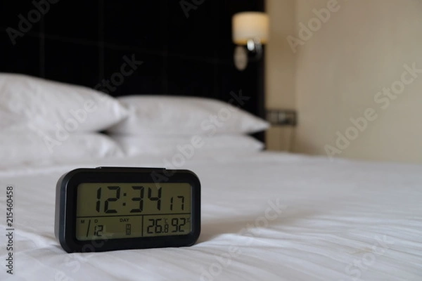 Obraz Large digital black clock on white bed in luxury bedroom