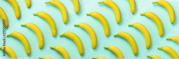 Fototapeta Geometric colorful fruit pattern. Bananas over blue background. Banner. Top view. Pop art design, creative summer concept. Minimal flat lay style.
