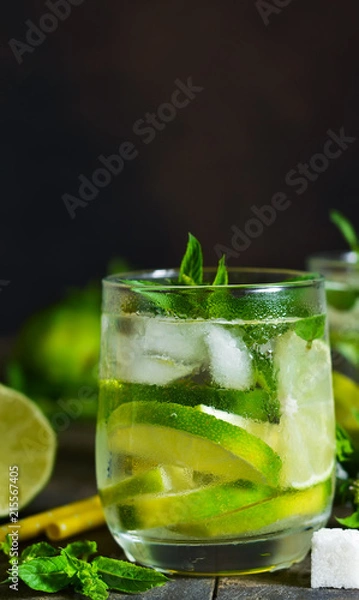 Fototapeta Cold alcohol mahito with mint and lime on a dark background. Summer drink.