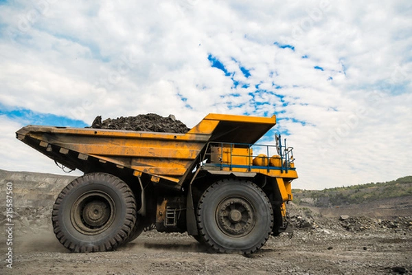 Obraz Large quarry dump truck. Loading the rock in dumper. Loading coal into body truck. Production useful minerals. Mining truck mining machinery, to transport coal from open-pit as the coal production.