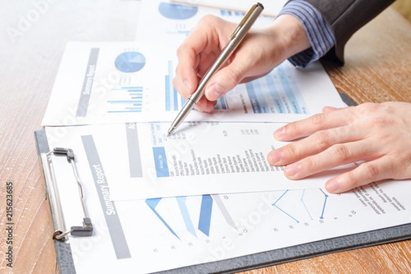 Obraz business man analyzing graph and chart document report