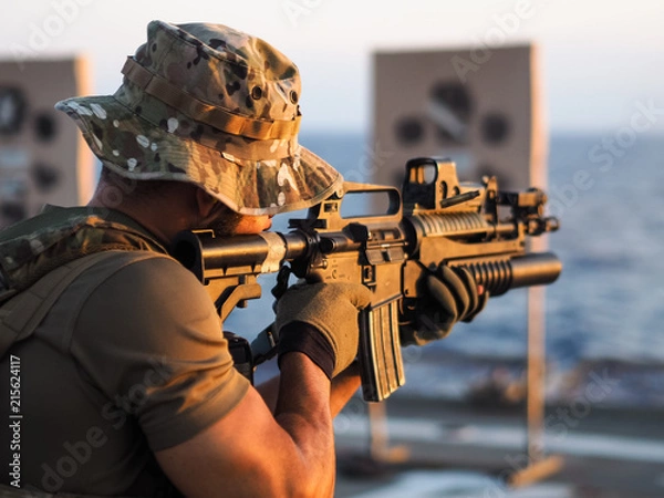 Obraz Man shooting rifle,shell ejecting