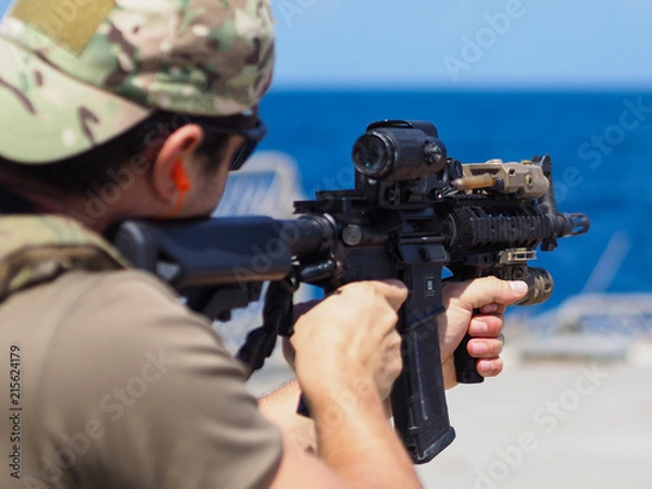 Obraz Man shooting rifle,shell ejecting