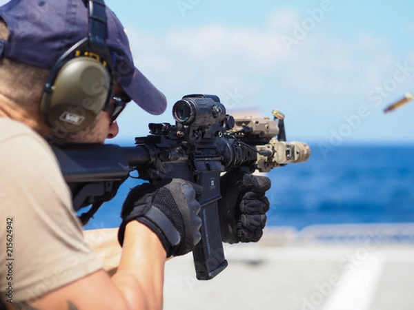 Obraz Man shooting rifle,shell ejecting