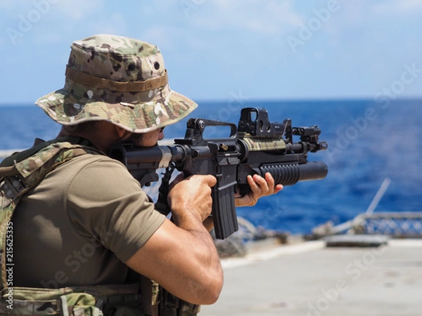 Obraz Man shooting rifle,shell ejecting