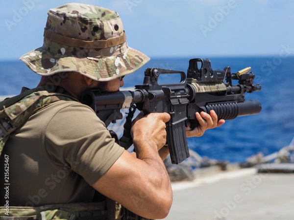 Obraz Man shooting rifle,shell ejecting